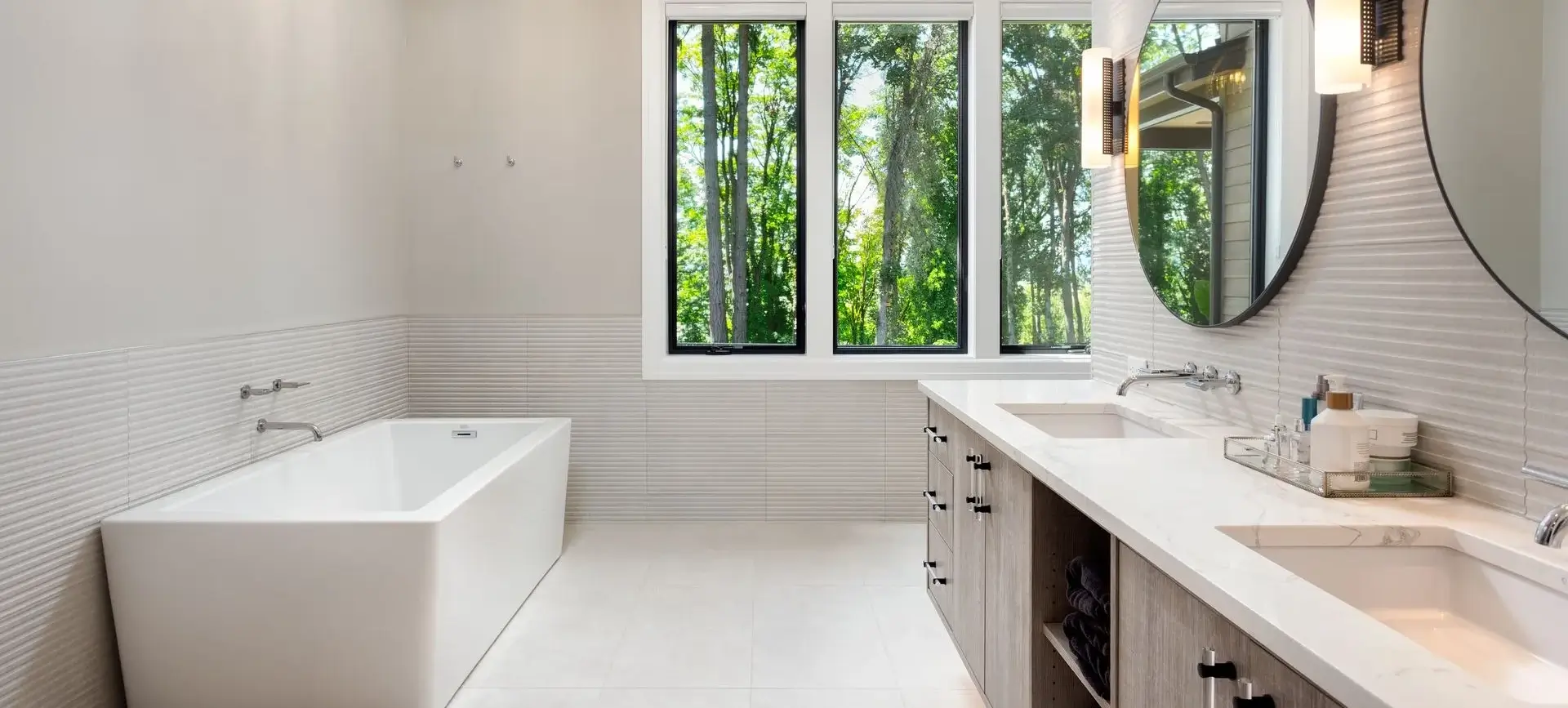 A bathroom with a tub and sink, and large windows.